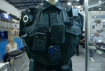 police portable cameras and walkie talkie radio hanging on Ukrainian woman police officer uniform...