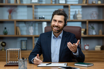 Fototapeta premium Experienced mature man in a suit and headset working from a well-organized home office, exuding confidence and charisma.