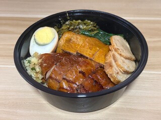 Cantonese mix rice bowl with soy sauce chicken, roasted duck thigh, egg and Vietnamese sausage. Cantonese food style.