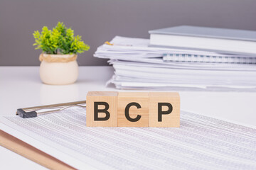There is word cube formed the word BCP. It's placed on a colored board.