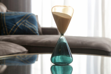 Modern hourglass on the coffee table in the living room, home decor concept	