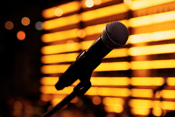 Close-up of a microphone on the stage with club light background.