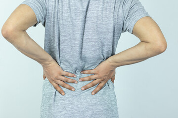 Man suffering from pain in the waist on a white background - obrazy, fototapety, plakaty
