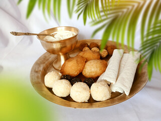 Assamese traditional food items like pitha, laddu, doi sira with assamese gamosa background with...