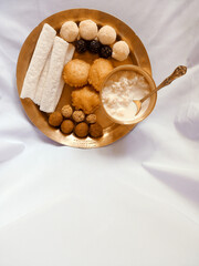 Assamese traditional food items like pitha, laddu, doi sira with assamese gamosa background with japi motifs