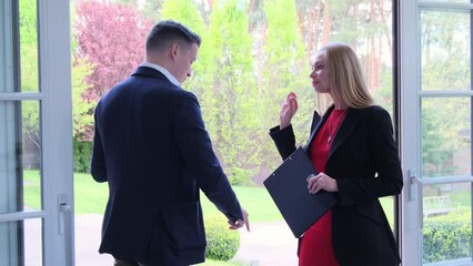 Blonde manager tells suburban cottage residence details to potential customer. Businessman buyer interested in offer from real estate agency