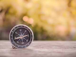 Close up compass on table in the sunset time. The concept of world tourism day, Searching the right directions and Travel