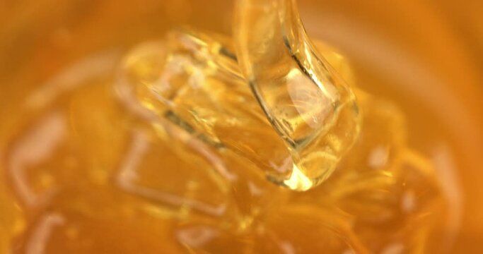 Super slow motion macro of bio organic golden sticky liquid honey is flowing and dripping at 1000 fps.