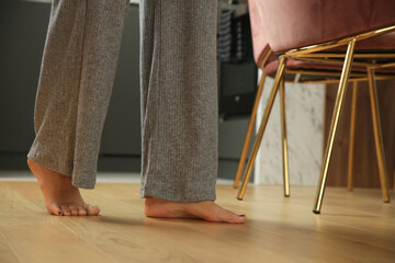 Barefoot woman on the wooden floor. Concept of the underfloor heating in the apartment.	
