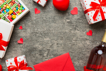 top view photo of st valentine day decor shopping, bag, wine, bottle, envelope, gift, box, candy and red heart on colored background with empty space. Frame background