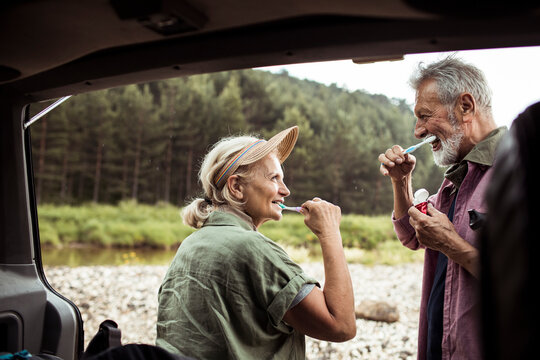Senior couple brushing teeth on camping trip