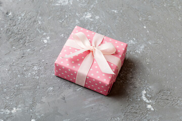wrapped Christmas or other holiday handmade gift box in color paper with ribbon on colored...