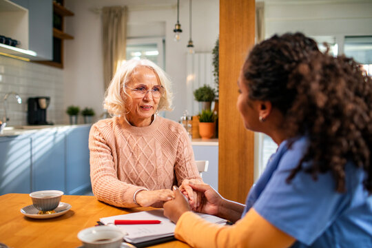 Senior woman talking to caregiver at home
