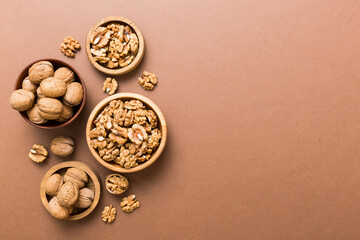 Walnut kernel halves, in a wooden bowl. Close-up, from above on colored background. Healthy eating Walnut concept. Super foods with copy space