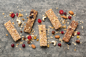 Various granola bars on table background. Cereal granola bars. Superfood breakfast bars with oats, nuts and berries, close up. Superfood concept