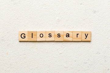 Glossary word written on wood block. Glossary text on cement table for your desing, Top view concept