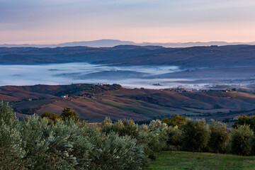 Elevated autumnal scenery panoramic perspective over Tuscany, Italy, valleys with thick fog. Amazing travel and tourist Italian destination.