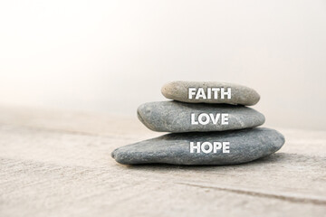Faith, Love and Hope. Motivational advice or reminder, on the stones