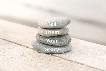 Tell them your story words written on stones. Copy space