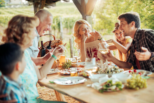 Happy family enjoying meal together in vineyard