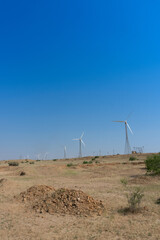 Pre dawn light in desert sky with Electrical power generating wind mills producing alterative eco friendly green energy for consumption by local people. Thar desert, Rajasthan, India.