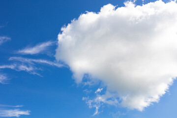 Naklejka na ściany i meble Fluffy and vibrant cloud with clear blue sky background