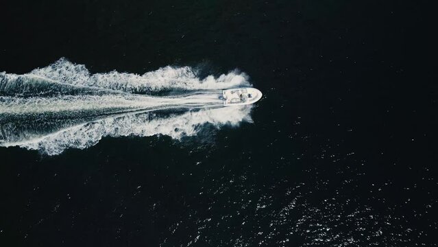 Top View of a motorboat cruising at high speed in the deep blue ocean 