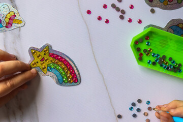 child draws paints diamonds mosaic