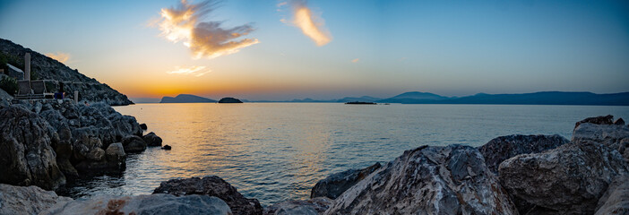 A panoramic view of the sunset over the Saronic Sea from Kamini harbor on Hydra Island, Greece