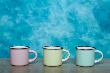 Colorful mugs on a blue background. Minimalism.