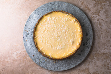 Raw vegan lime coconut cheesecake on marble table, background