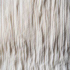 Close-up of textured white woven fabric with irregular raised patterns