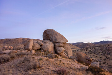 Fototapeta na wymiar Sun setting behind the Mojave Desert hills and boulders in Apple Valley, CA