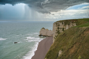 Etretat in Normandy, the famous cliffs and needle on the pebble beach
