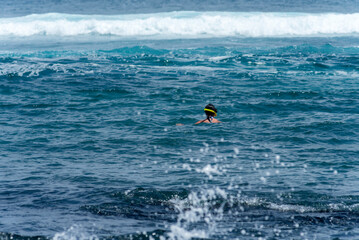 beach landscape with the sea and waves and cliffs of the coasts of the Galapagos Islands in the Pacific Ocean with blue and green water and volcanic rocks
