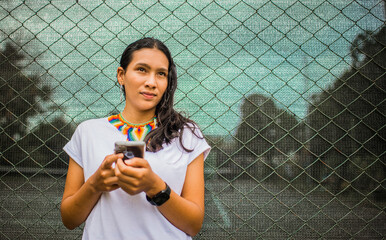 mujer con un teléfono inteligente y conexión a Internet con redes sociales y sms al aire libre 