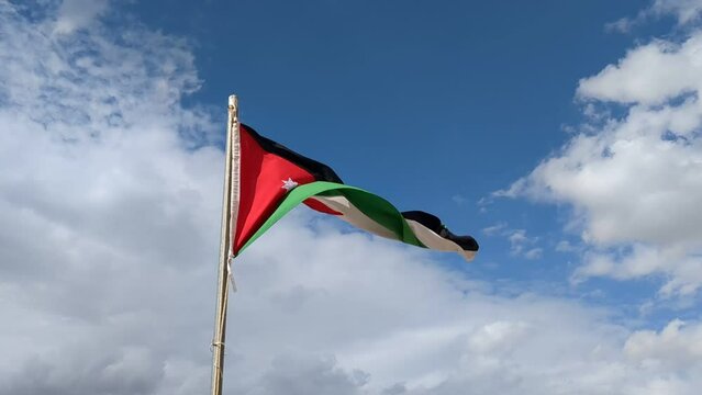 Jordan national flag waving in beautiful sky over Wadi Rum valley
