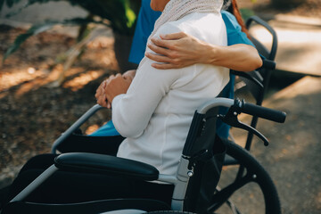 Fototapeta na wymiar A nurse take care a senior male on wheelchair in his garden at home