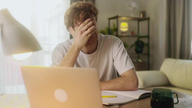 Shocked red haired male reacting to news and feel confused surprised ashamed making face palm gesture disappointed in result having problem or bad news at home workplace 