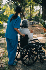 A nurse take care a senior male on wheelchair in his garden at home