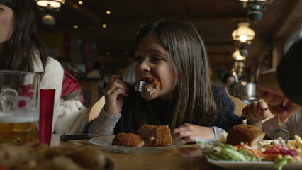 Cozy Dining Delight - Little Girl Enjoying Cordon Bleu Chicken at Family Mealtime in Wooden Interior Diner, people eating food at restaurant