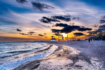 Foto op Canvas sunset on icy beach in winter with dramatic clouds and  downtown skyline in distant background shot kew beach toronto room for text © Michael Connor Photo