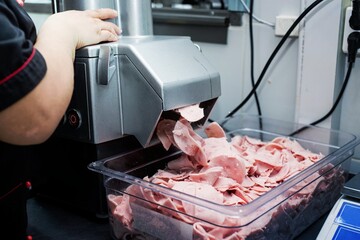 woman is working on meat grinder machine, forcemeat process for making sausages