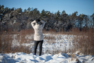  Young woman walking on a mountain snow trail in winter