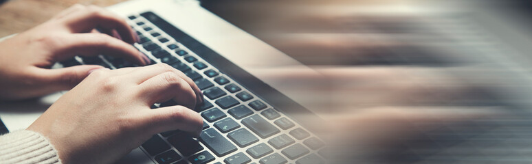 woman's hands using and typing on laptop keyboard