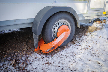 An immobilizer from the public order office is attached to one wheel of a trailer - obrazy, fototapety, plakaty
