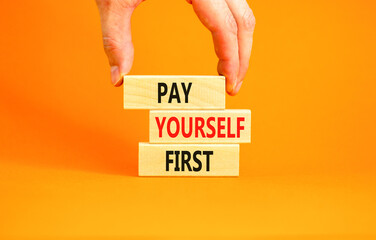 Pay yourself first symbol. Concept words Pay yourself first on beautiful wooden blocks. Beautiful orange table orange background. Businessman hand. Business and pay yourself first concept. Copy space.