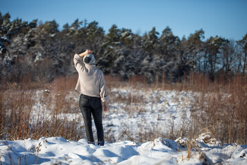 Młoda kobieta spacerująca zimą po górskim szlaku śnieżnym - obrazy, fototapety, plakaty