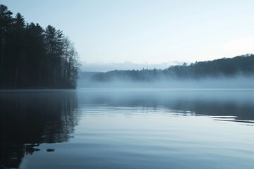Obraz premium Tranquil lake with a clear reflection of trees on the water and morning mist at dawn