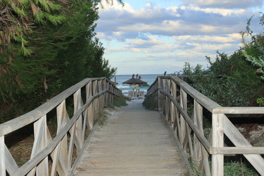 Puente de madera con sombrillas de playa en el fondo